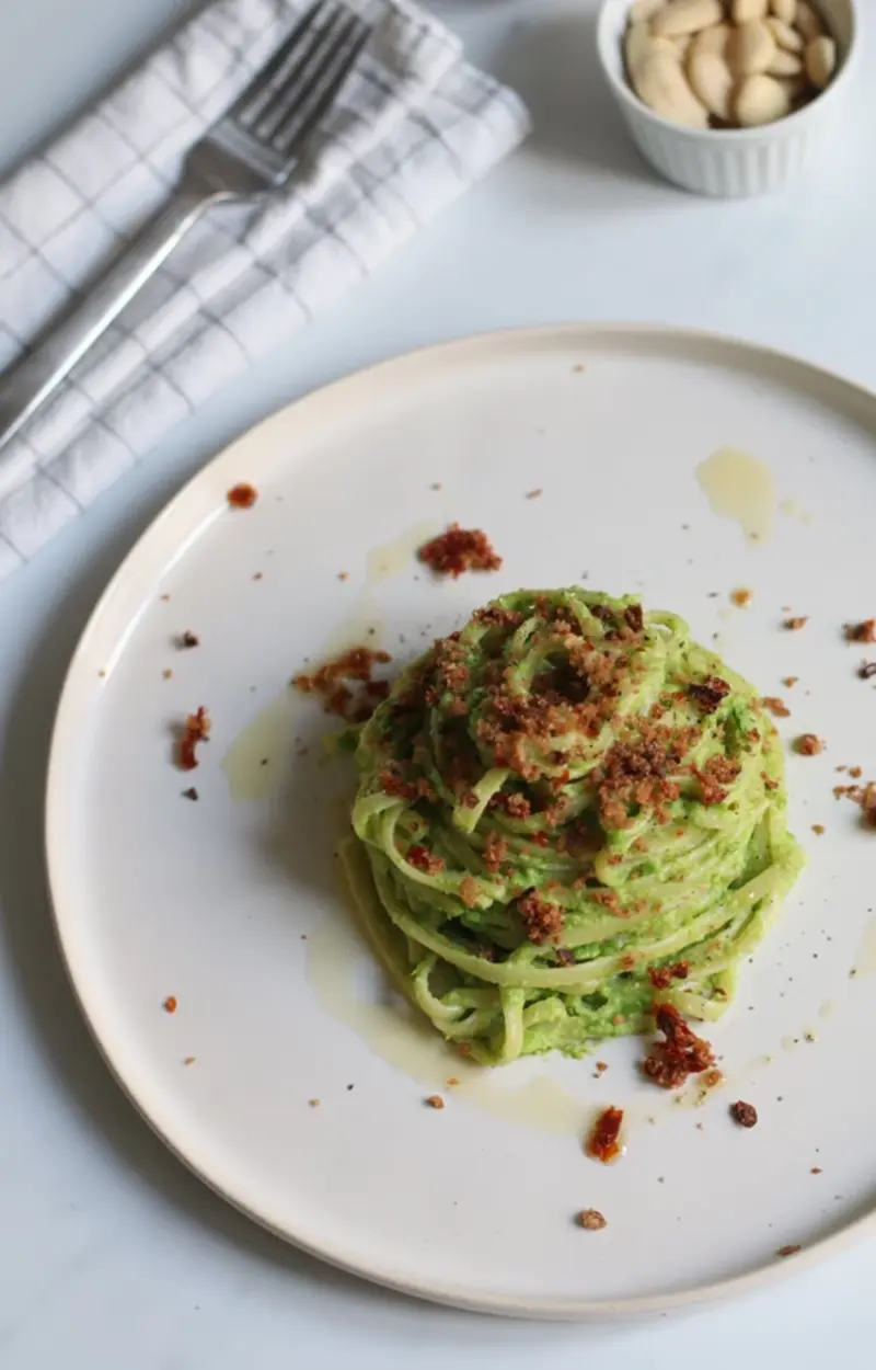 Linguine al pesto di piselli con pangrattato ai pomodori secchi e olive ricetta