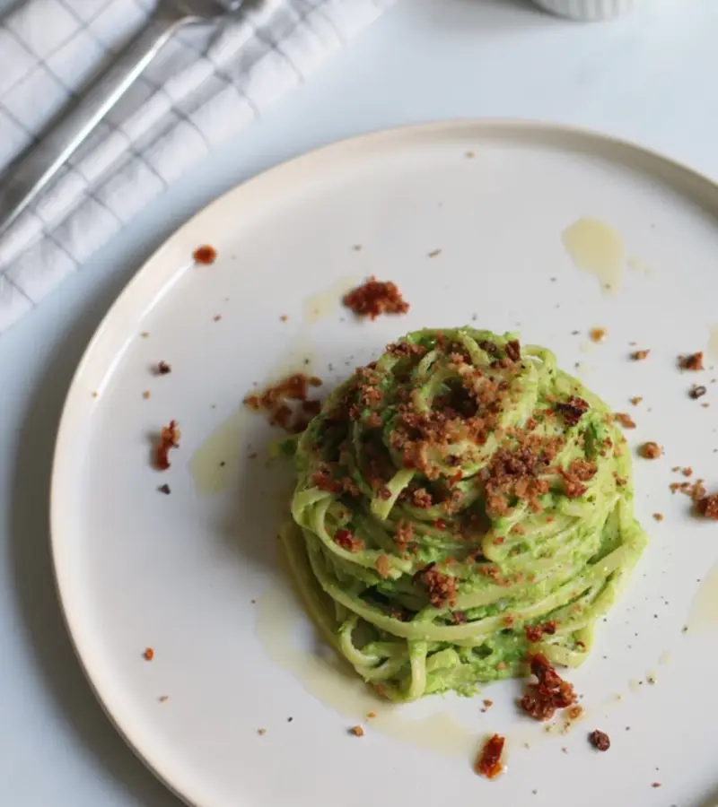 Linguine al pesto di piselli con pangrattato ai pomodori secchi e olive ricetta